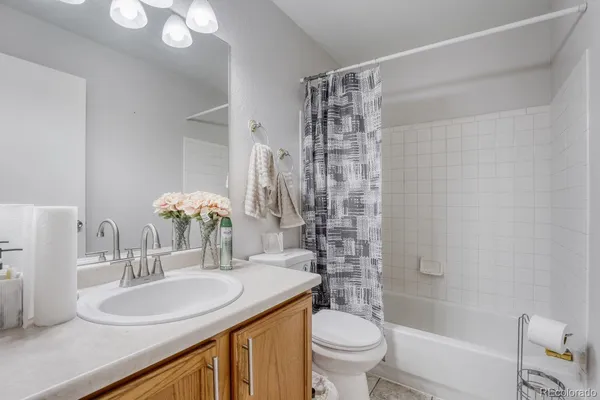 a bathroom with a granite countertop sink a toilet a mirror and shower