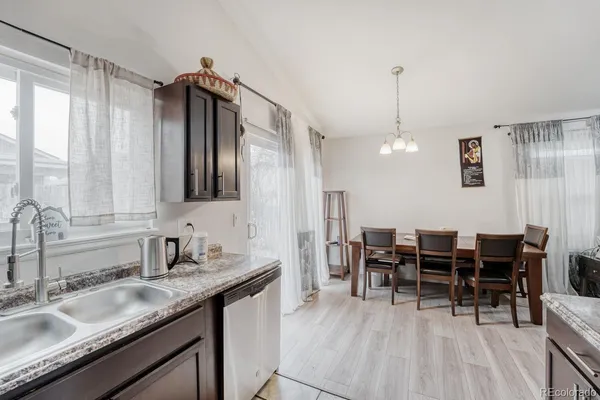 a kitchen with granite countertop a sink cabinets and stainless steel appliances