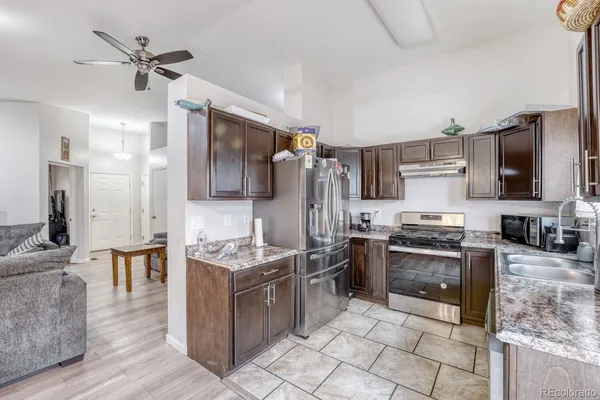 a kitchen with stainless steel appliances granite countertop a stove refrigerator and microwave