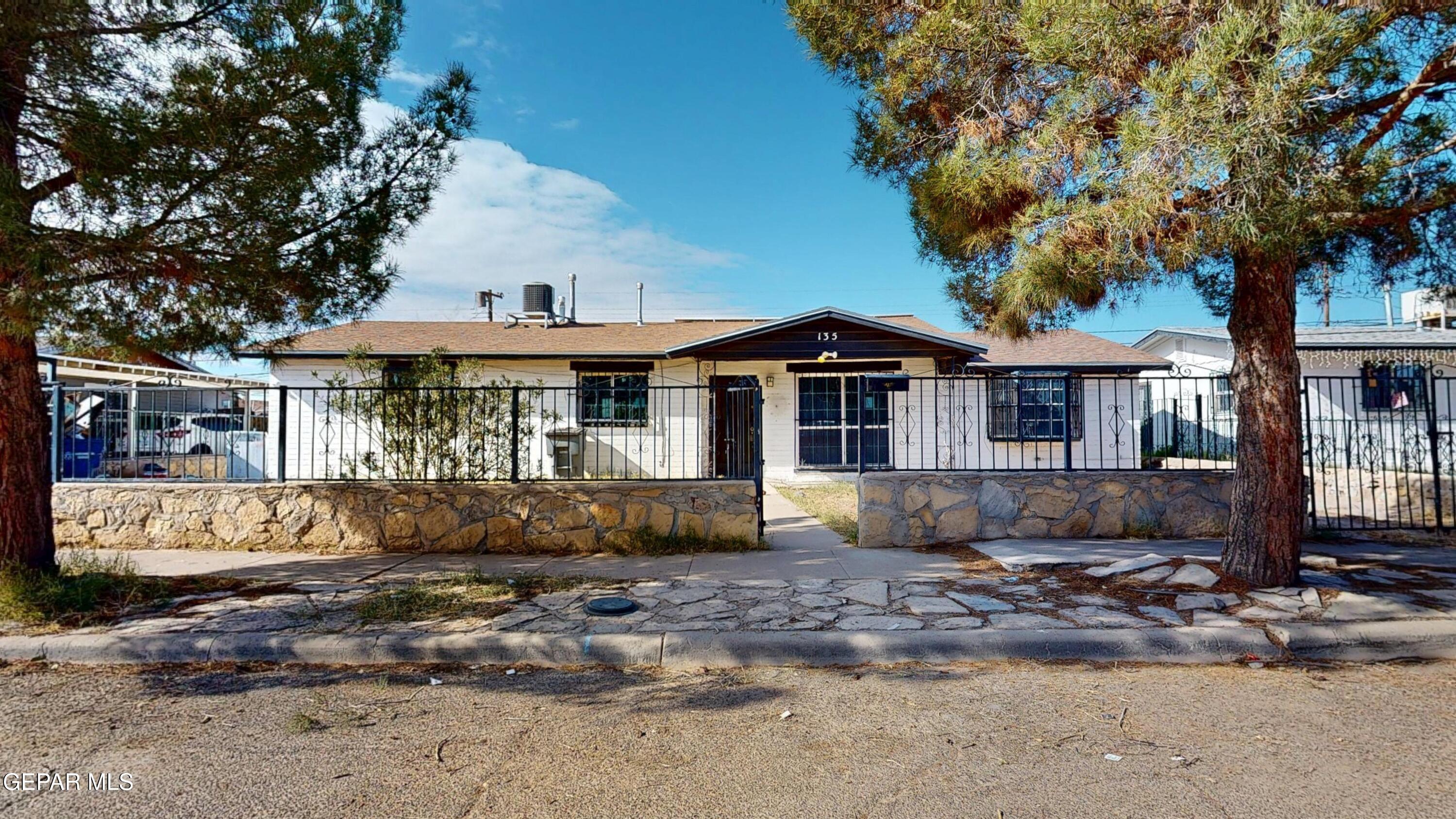 a front view of a house with a tree