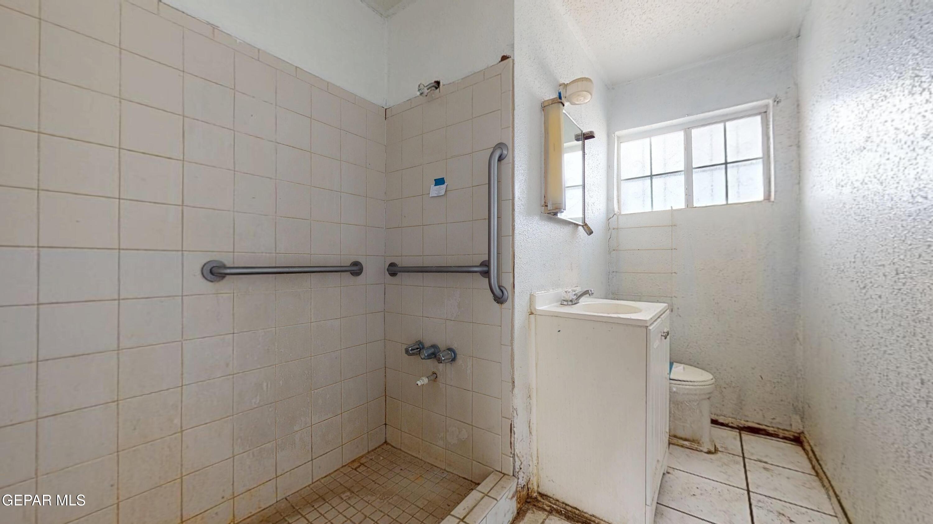 135 Baywood Road El Paso, TX 79915 - Photo 14 of 43 a bathroom with a granite countertop toilet a sink and shower