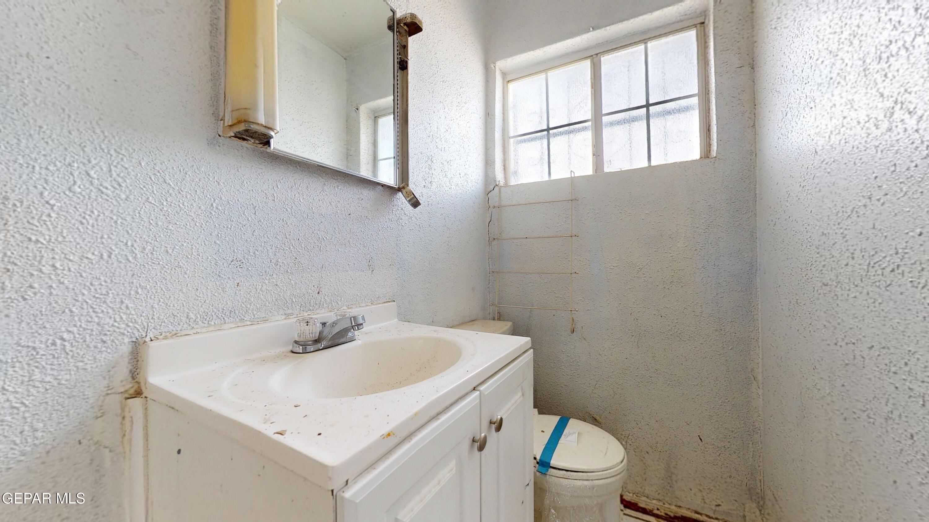135 Baywood Road El Paso, TX 79915 - Photo 15 of 43 a bathroom with a sink a toilet and a window