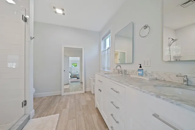 a spacious bathroom with a granite countertop sink a mirror and a toilet