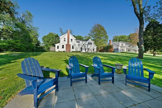 a view of a chairs and table in the back yard of the house
