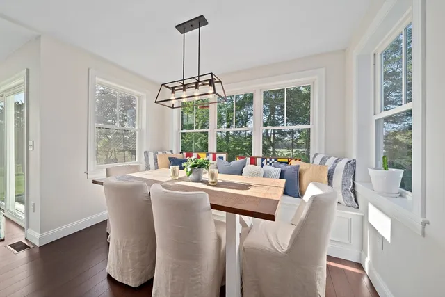 a dining room with furniture a chandelier and wooden floor