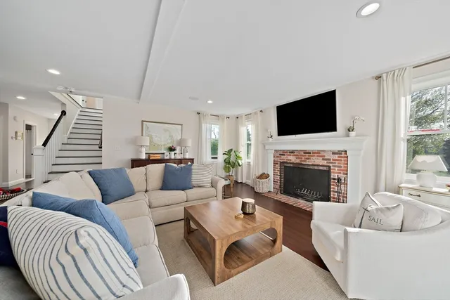 a living room with furniture a flat screen tv and a fireplace