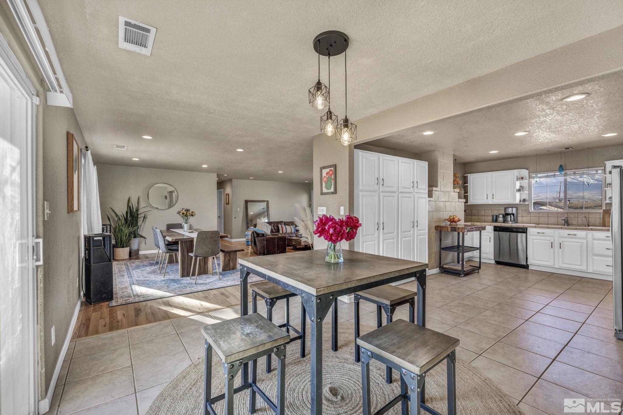 14660 Chamy Drive Reno, NV 89521 - Photo 17 of 38 a room with stainless steel appliances kitchen island granite countertop a dining table chairs and stove top oven