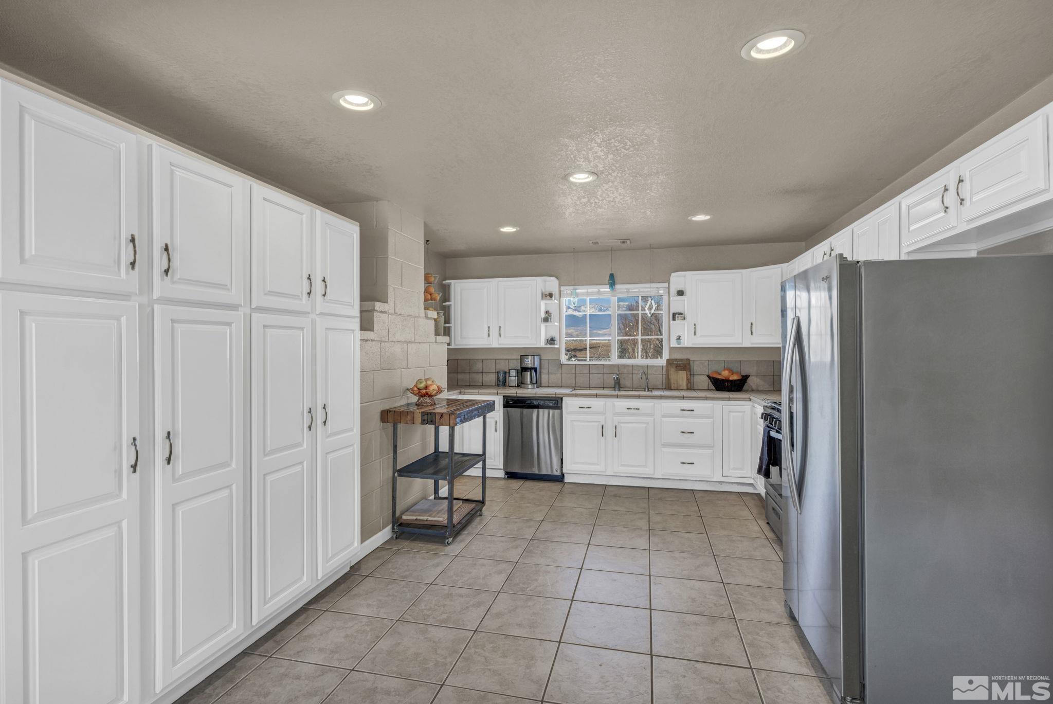 14660 Chamy Drive Reno, NV 89521 - Photo 18 of 38 a kitchen with a refrigerator and white cabinets