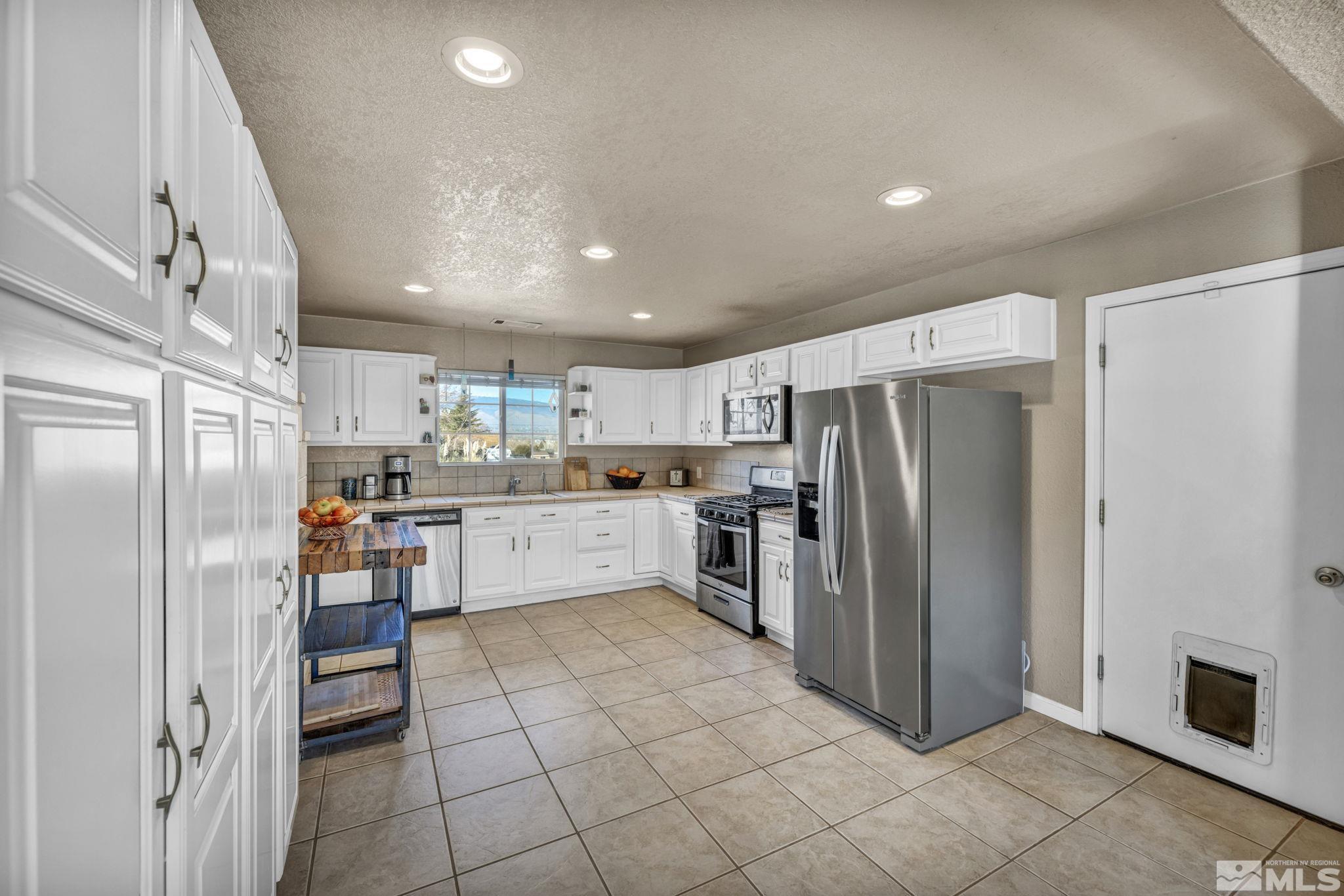 14660 Chamy Drive Reno, NV 89521 - Photo 19 of 38 a kitchen with stainless steel appliances a refrigerator and a stove top oven