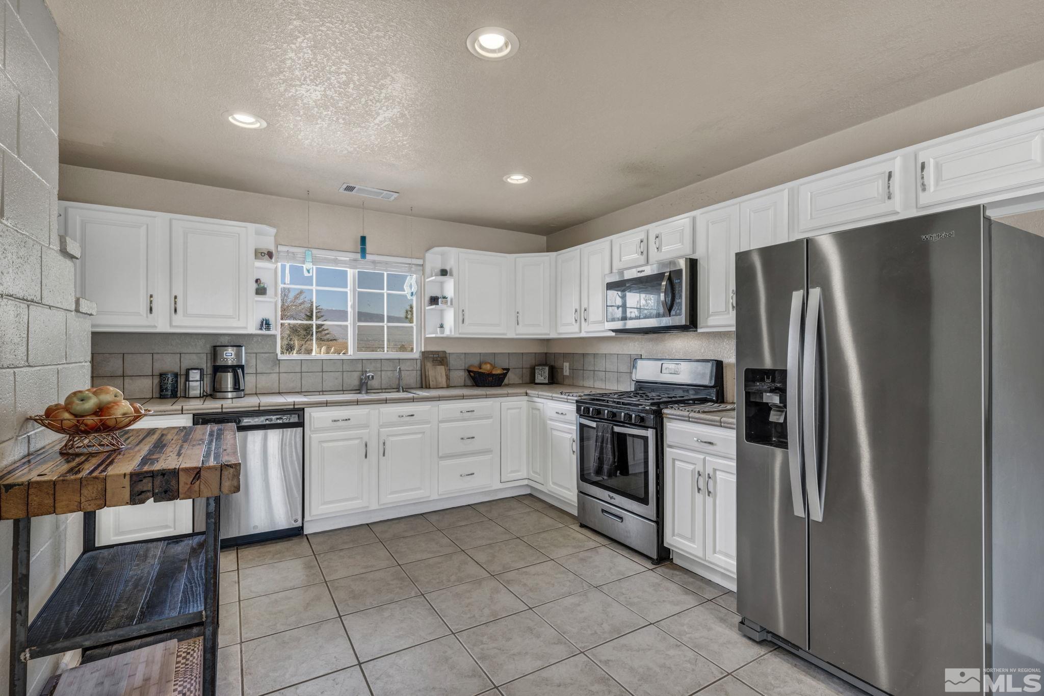 14660 Chamy Drive Reno, NV 89521 - Photo 20 of 38 a kitchen with stainless steel appliances granite countertop a refrigerator and a stove top oven