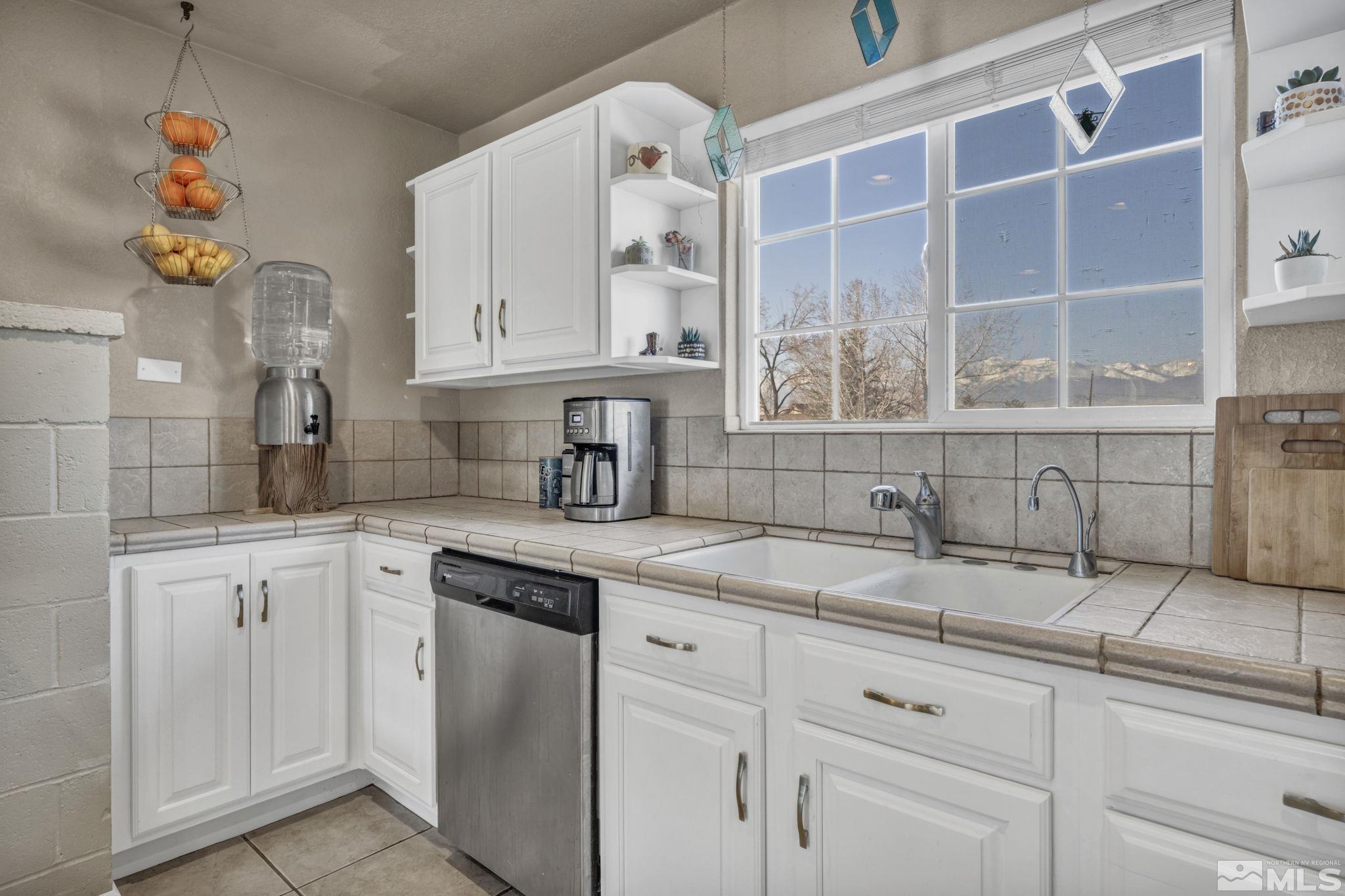 14660 Chamy Drive Reno, NV 89521 - Photo 21 of 38 a kitchen with granite countertop a sink stainless steel appliances white cabinets and a window