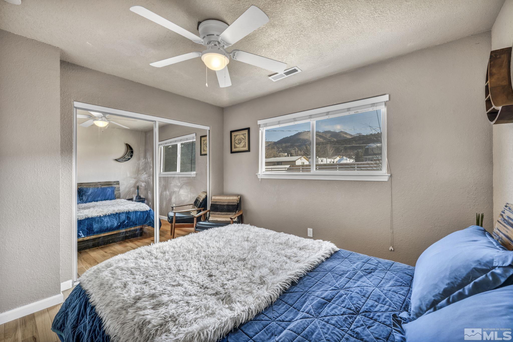 14660 Chamy Drive Reno, NV 89521 - Photo 29 of 38 a bedroom with a large bed and a chandelier