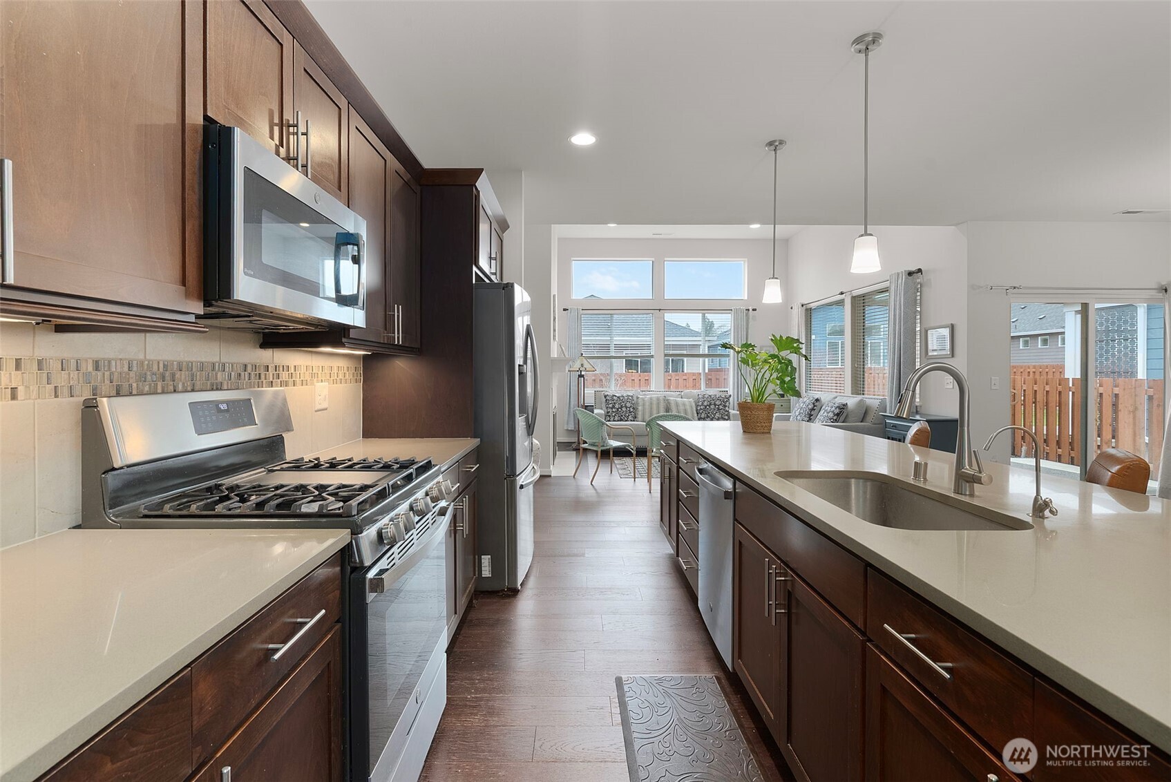 3311 Colville Street Southeast Lacey, WA 98513 - Photo 6 of 40 a kitchen with stainless steel appliances granite countertop a sink a stove and a wooden floors