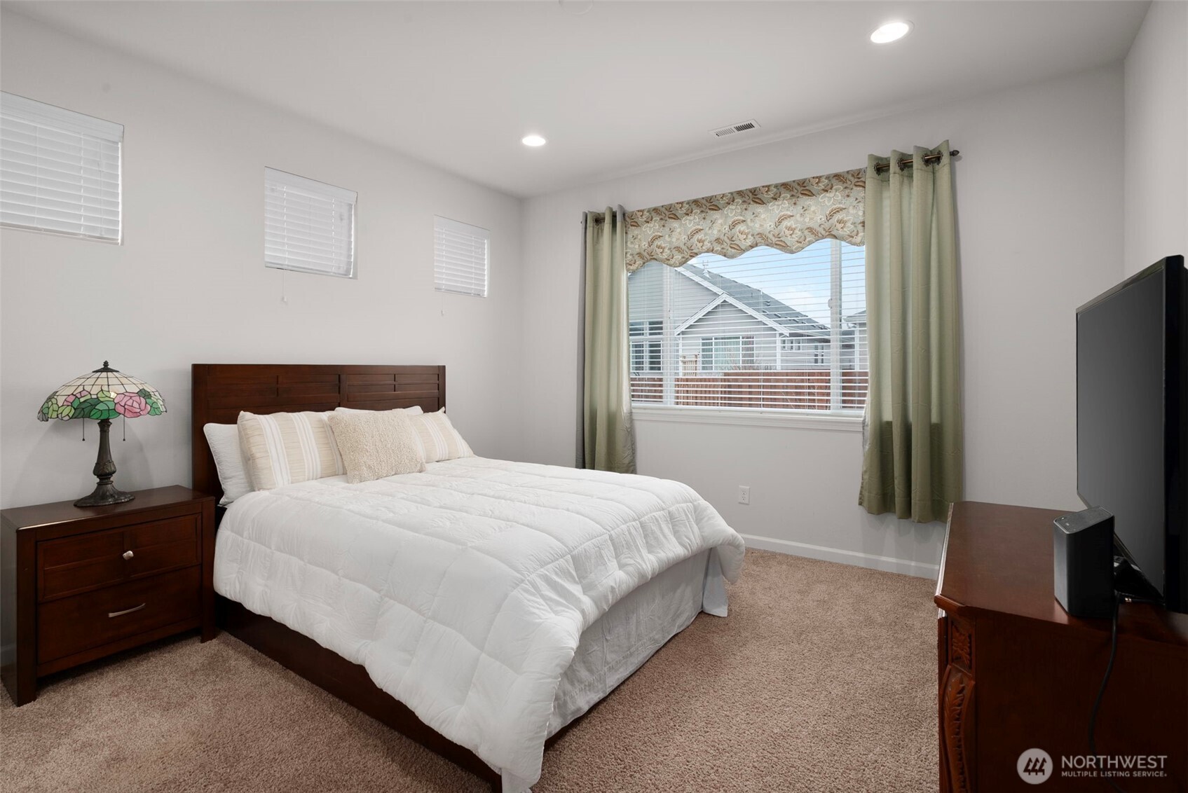 3311 Colville Street Southeast Lacey, WA 98513 - Photo 10 of 40 a bedroom with a bed and a flat tv screen on the dresser