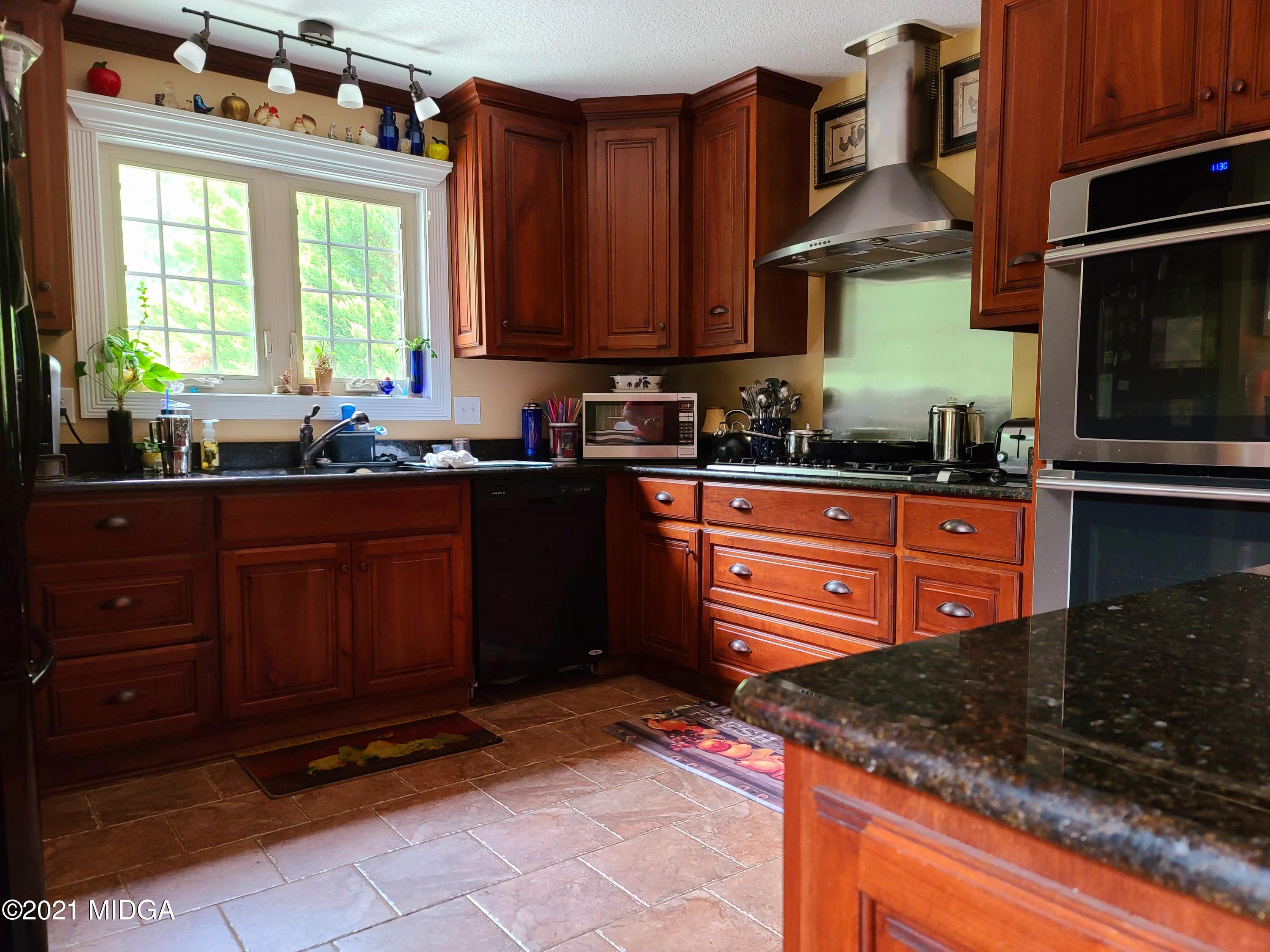 464 Loblolly Lane Macon, GA 31220 - Photo 11 of 48 a kitchen with granite countertop a sink a stove a microwave and cabinets