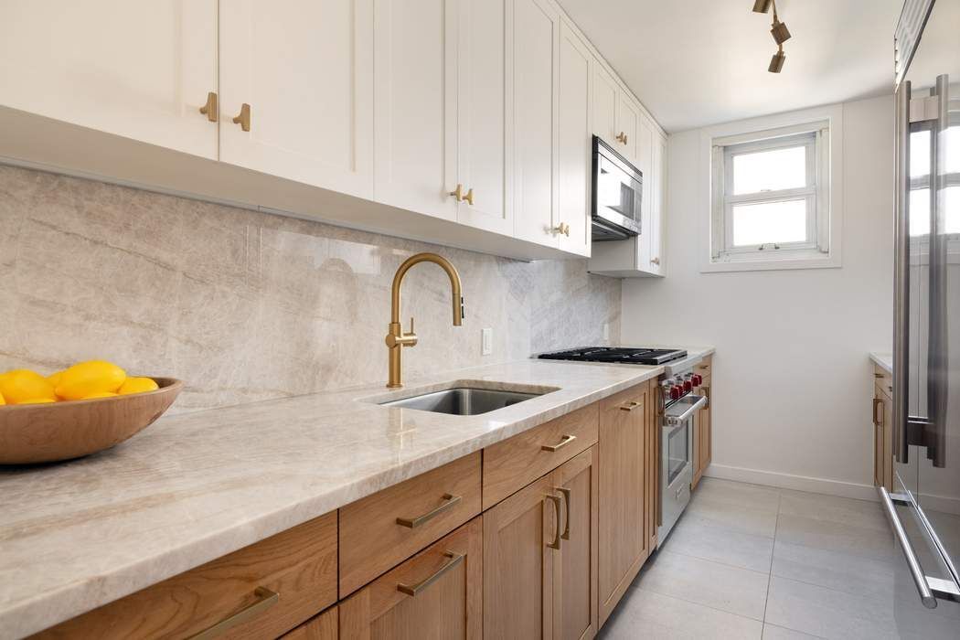 501 East 79th Street, Unit 14E Manhattan, NY 10075 - Photo 7 of 19 a kitchen with stainless steel appliances granite countertop a sink and cabinets