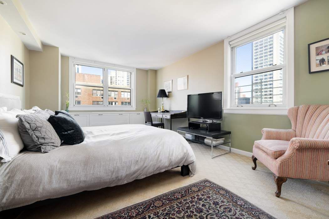 501 East 79th Street, Unit 14E Manhattan, NY 10075 - Photo 9 of 19 a bedroom with a bed and a couch