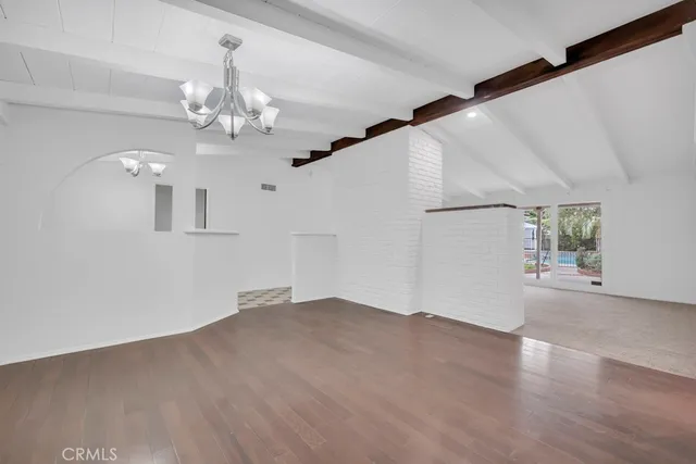 a view of a livingroom with wooden floor and a floor to ceiling window