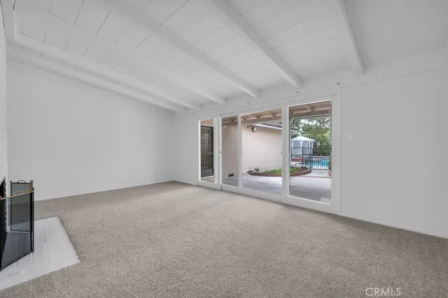 a view of an empty room with a fireplace and a window