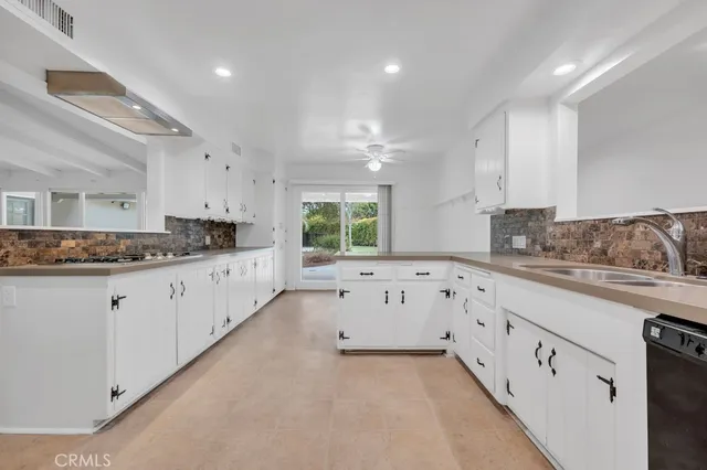 a kitchen with granite countertop white cabinets and a sink