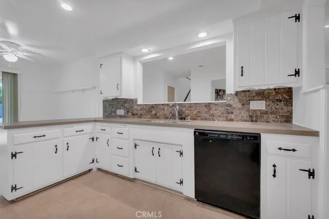 a kitchen with white cabinets and appliances