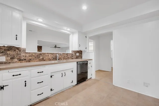 a large white kitchen with granite countertop white cabinets and a granite counter tops