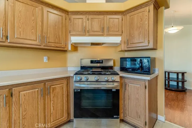a kitchen with granite countertop white cabinets and stainless steel appliances