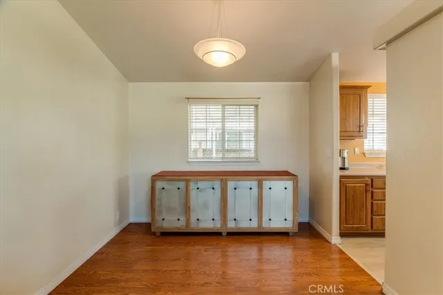 a view of a bedroom with wooden floor and windows