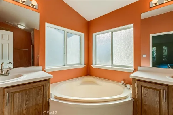 a bathroom with a tub sink and mirror