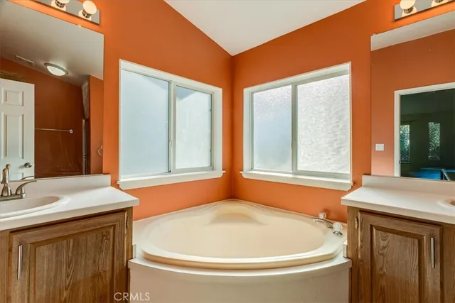 a bathroom with a tub sink and mirror