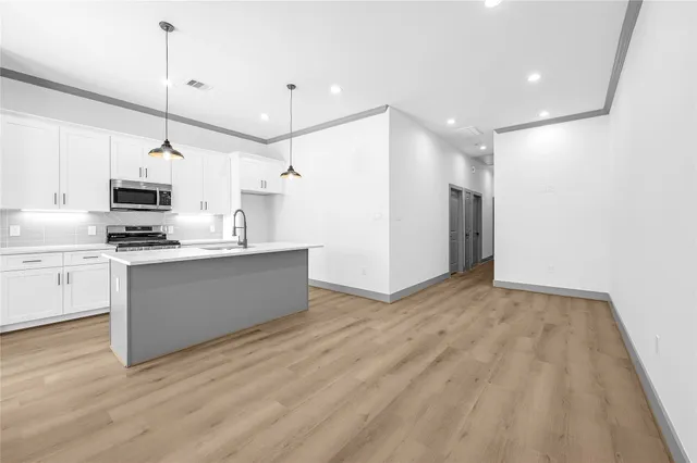 a kitchen with kitchen island white cabinets and stainless steel appliances