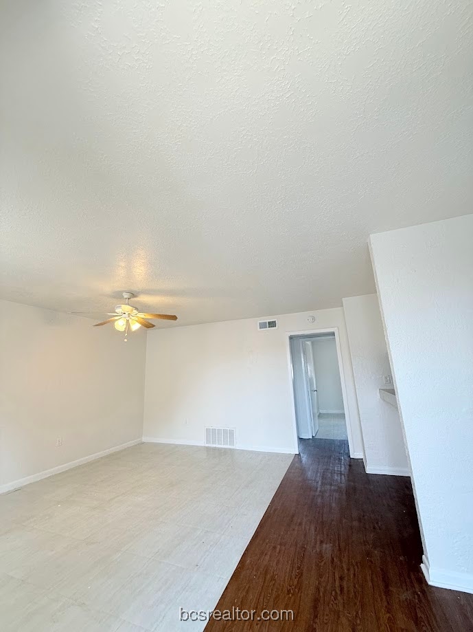 3300 South College Avenue, Unit B4 Bryan, TX 77801 - Photo 2 of 7 Unfurnished room featuring a textured ceiling, ceiling fan, and wood finished floors