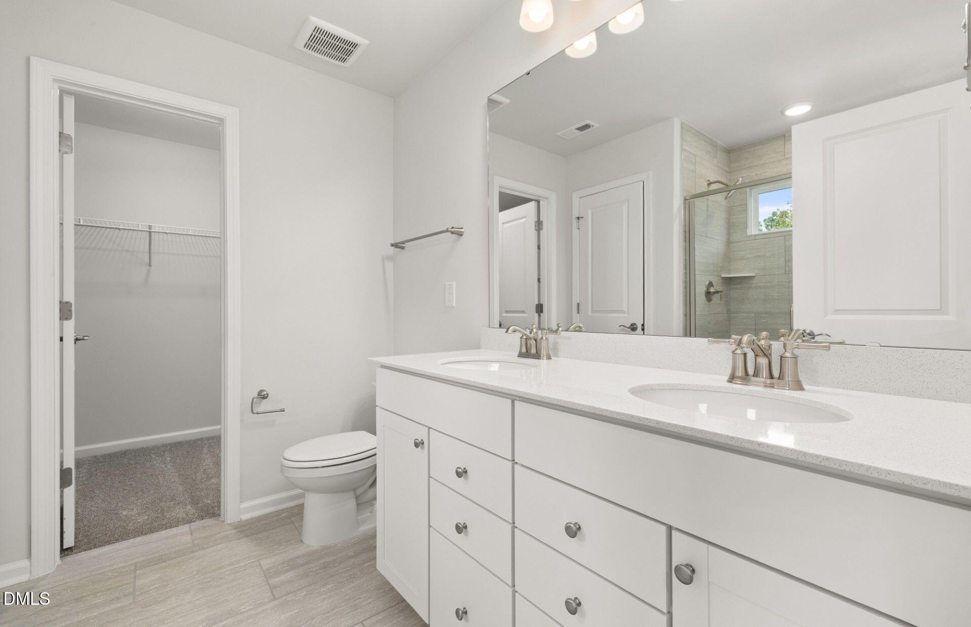 637 Fosterton Cottage Way Raleigh, NC 27603 - Photo 11 of 31 a bathroom with a double vanity sink toilet and shower