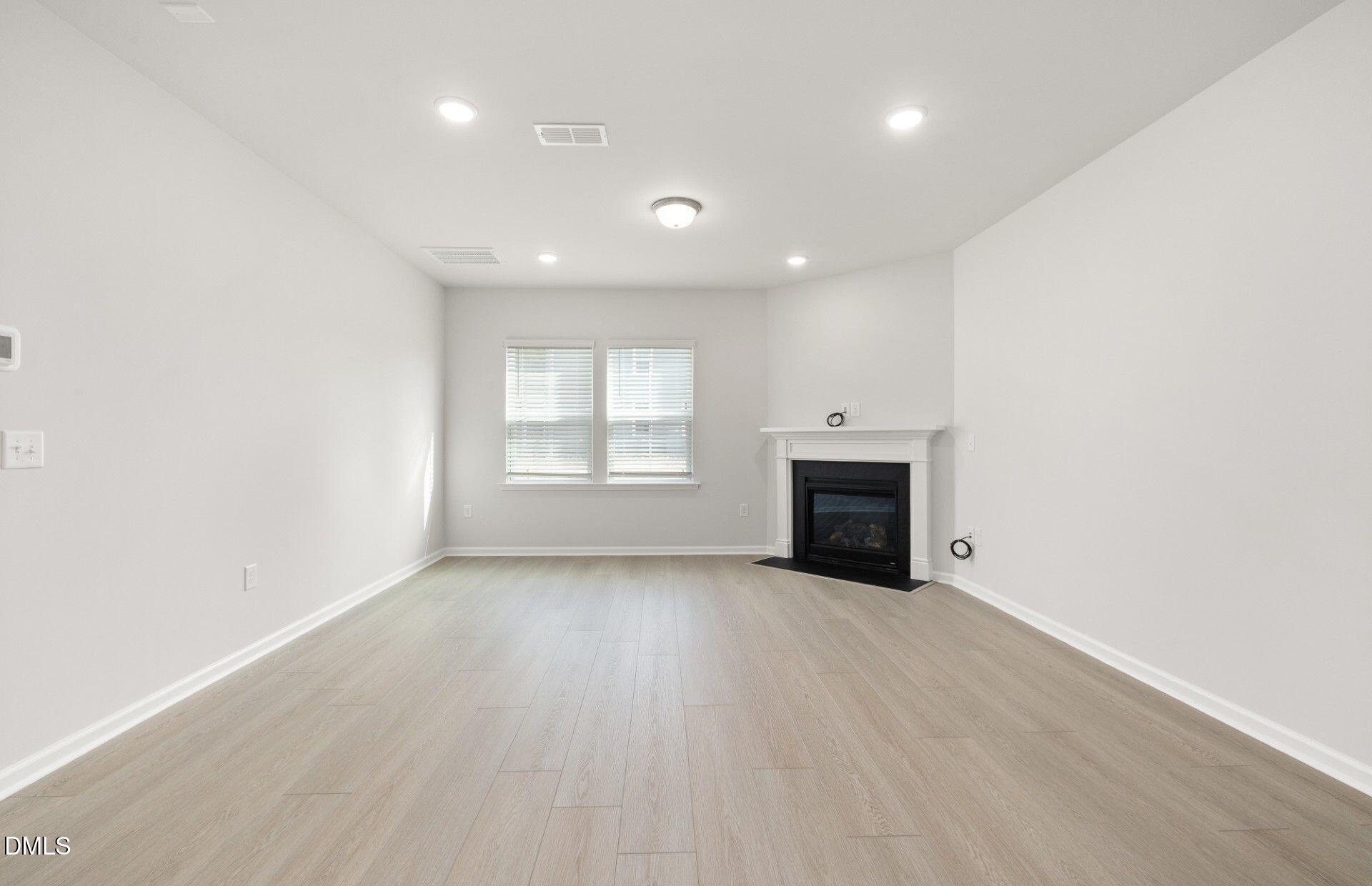 637 Fosterton Cottage Way Raleigh, NC 27603 - Photo 8 of 31 an empty room with windows and fireplace