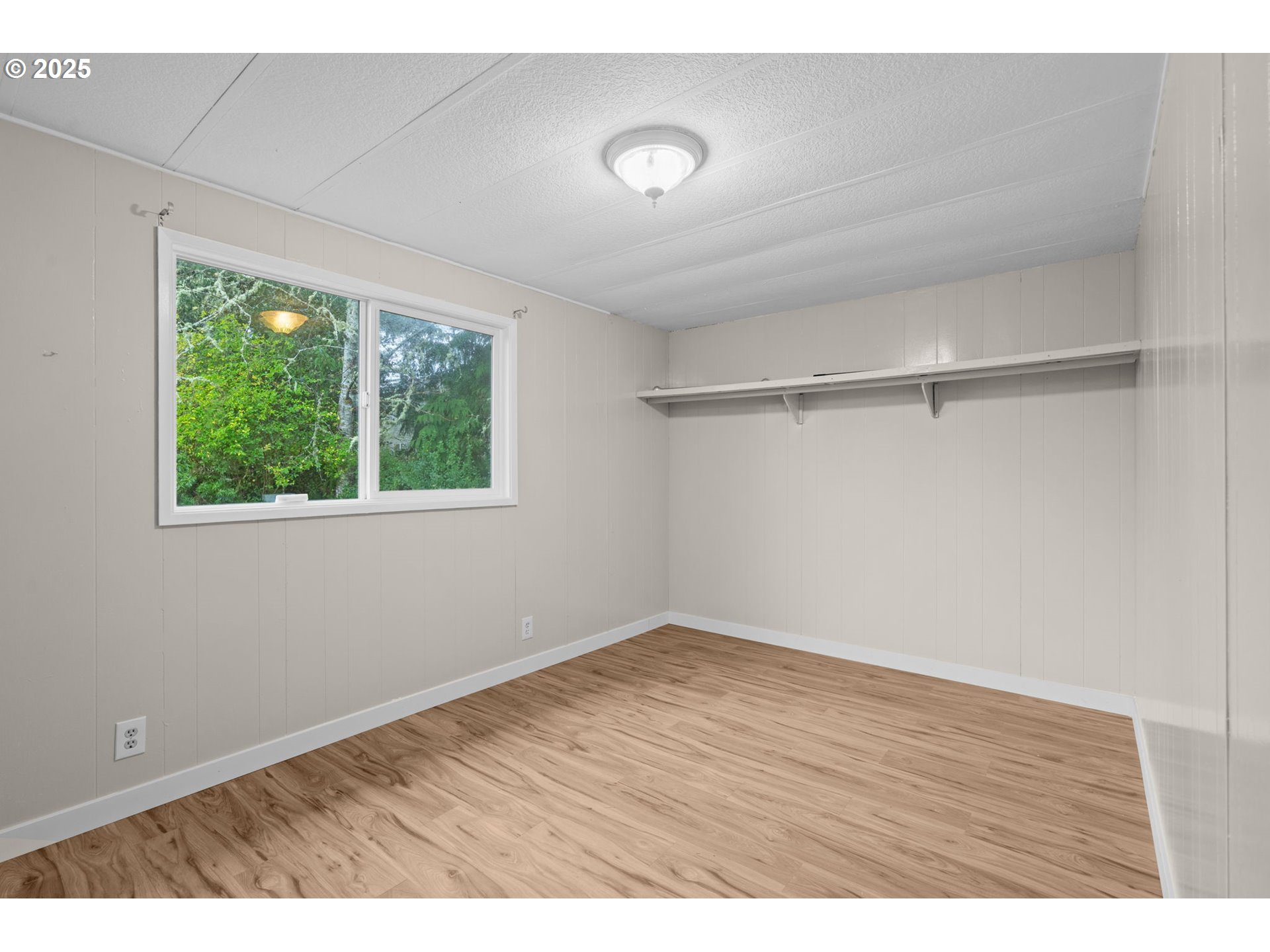 2657 North Highway 101, Unit 6 Seaside, OR 97138 - Photo 10 of 13 a view of an empty room with wooden floor and a window