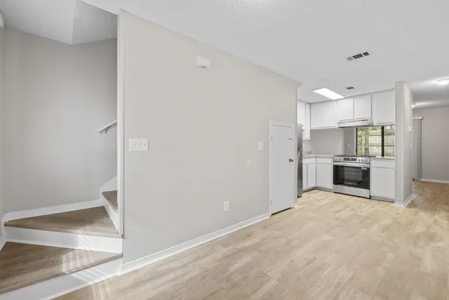 a view of a kitchen with refrigerator and a sink