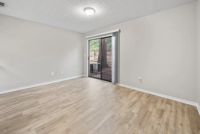 a view of an empty room with wooden floor