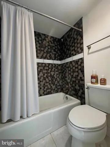 a bathroom with a toilet and a shower curtain