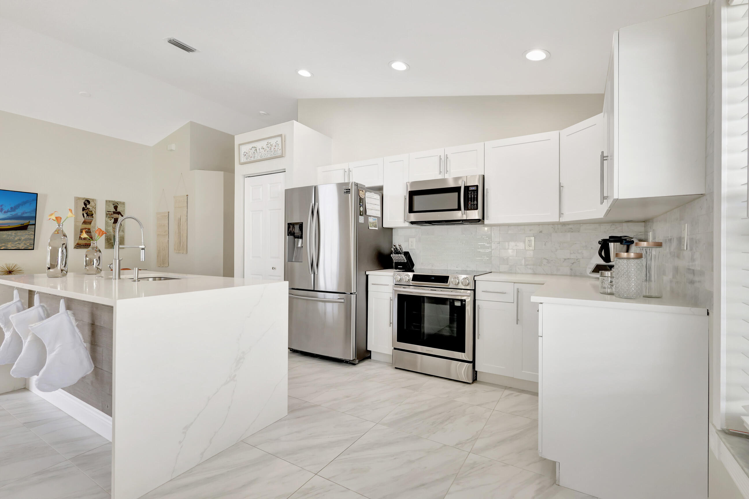 12204 Sunset Point Circle Wellington, FL 33414 - Photo 13 of 40 a kitchen with stainless steel appliances a refrigerator stove microwave and sink