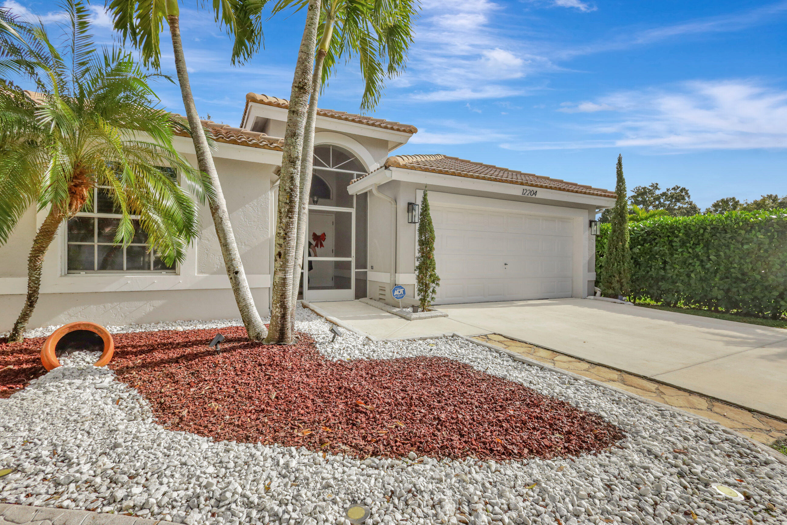 12204 Sunset Point Circle Wellington, FL 33414 - Photo 3 of 40 a front view of a house with a yard