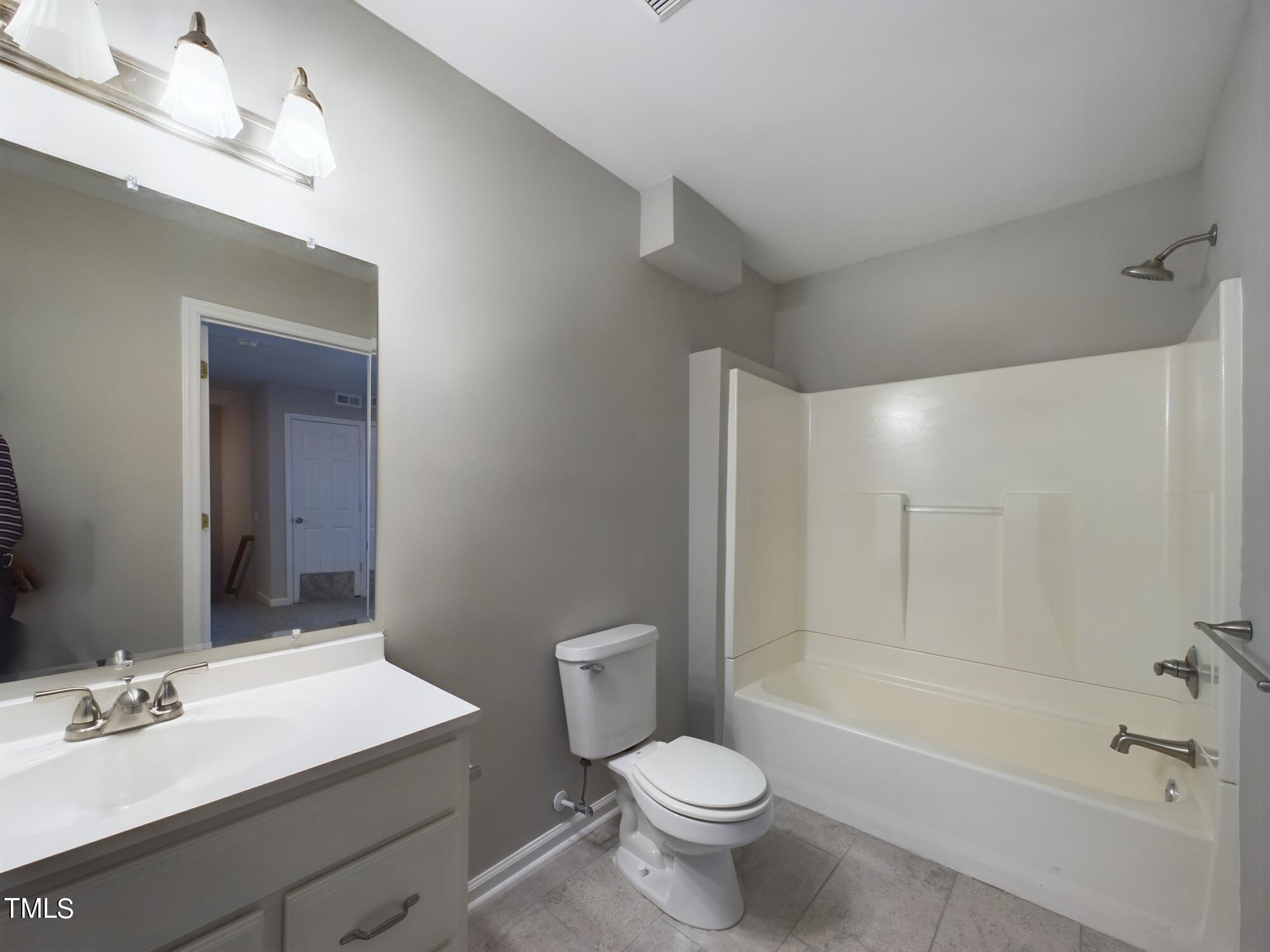 11124 Slider Drive Raleigh, NC 27614 - Photo 54 of 62 a bathroom with a sink a toilet a mirror a bathtub and shower