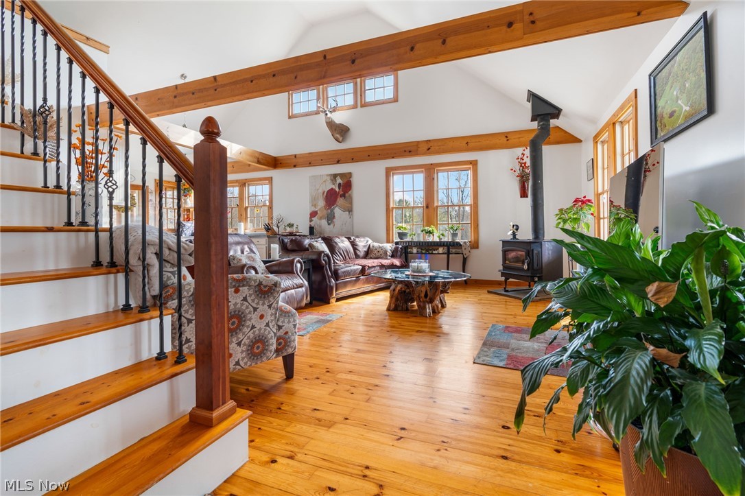 2210 Scroll Road Southwest Carrollton, OH 44615 - Photo 4 of 48 Living area with light wood-style floors, a wood stove, and a high ceiling