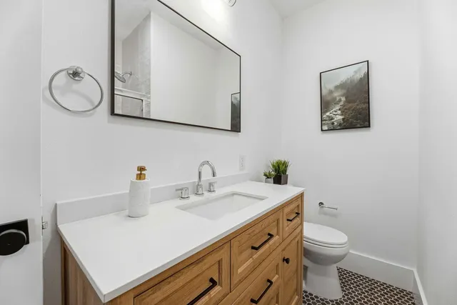 a bathroom with a sink mirror and toilet