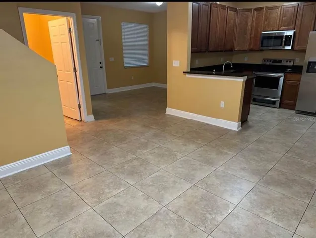 a kitchen with stainless steel appliances granite countertop a refrigerator a stove and a microwave