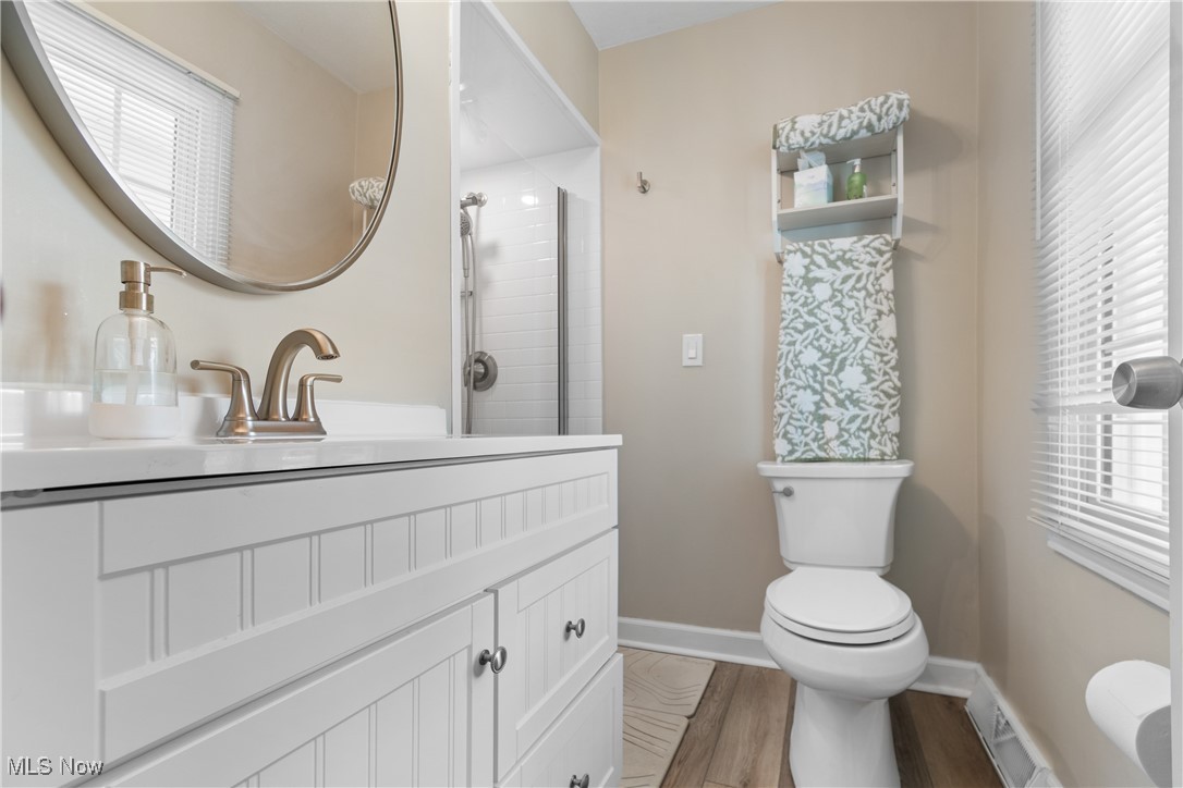 4401 Conestoga Trail Akron, OH 44321 - Photo 18 of 35 Bathroom with healthy amount of natural light, wood finished floors, vanity, and a shower