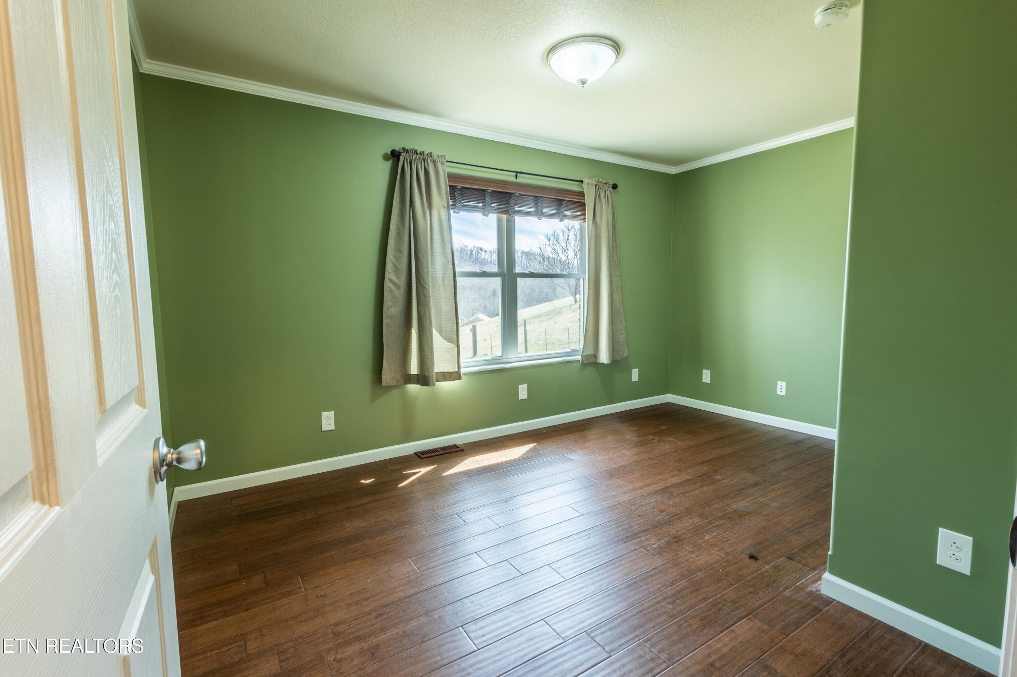 1208 Dutch Valley Road Clinton, TN 37716 - Photo 10 of 21 an empty room with wooden floor and windows