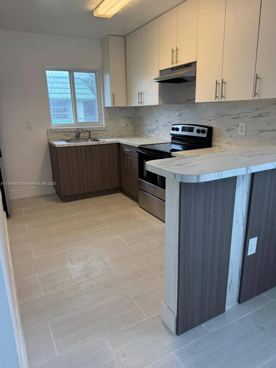 800 Northwest 44th Avenue, Unit 4 Miami, FL 33126 - Photo 2 of 9 a kitchen with granite countertop a sink a stove and a refrigerator