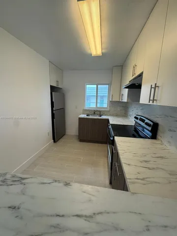 a kitchen with refrigerator and window