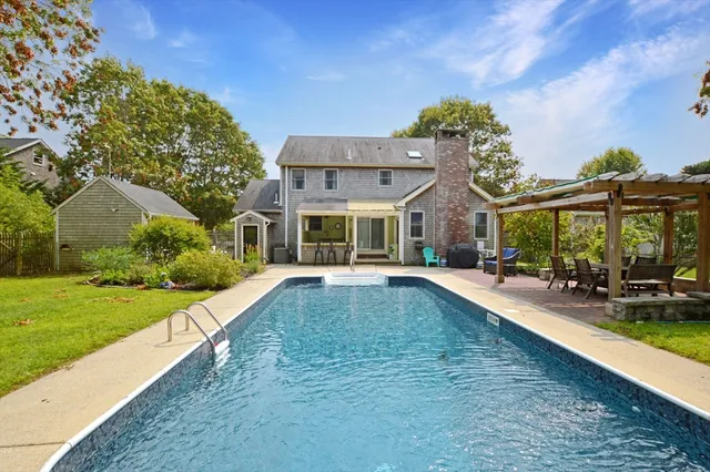a view of a house with a swimming pool and a yard