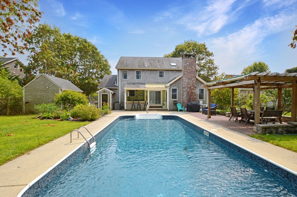 a view of a house with a swimming pool and a yard